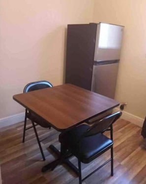 A small dining area with a wooden table and two black chairs. - Private Suite # 11, five minutes walk to beach (Pompano Beach)
