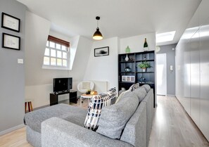 Relax in this cozy living space with a sofa, armchair, and flat-screen TV.