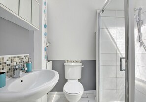 Bathroom features a sink, toilet, and glass shower enclosure.