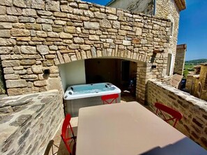 A stone wall with a stone oven, a table, and red chairs. - LE PONT Junior Luxury Suite with private Jacuzzi (Martignargues)