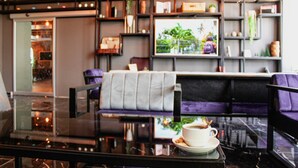 Un intérieur moderne avec un canapé, une table basse et des étagères remplies de divers objets.