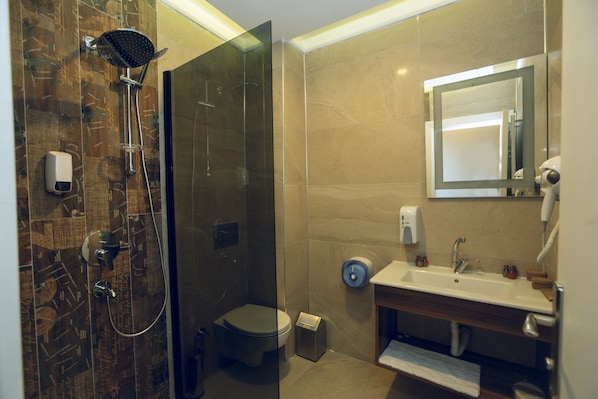A modern bathroom with a glass-enclosed shower, a toilet, and a sink with a mirror above it. - Grand Catalkaya Hotel (Erzurum)