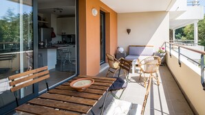 Un balcone con arredi in legno, un divano e un tavolo da pranzo.