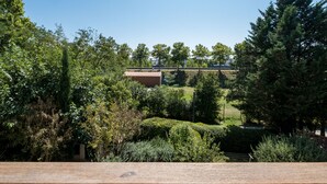 Vista di un parco con un ponte, alberi e un edificio sullo sfondo.