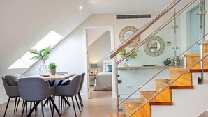 A modern loft apartment with a dining area, a staircase, and a bedroom. - Exclusive 2BD duplex in Malaga old town. San Agustin Terrace III (Malaga)