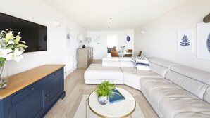 Een moderne woonkamer met een bank, salontafel en een flatscreen televisie.