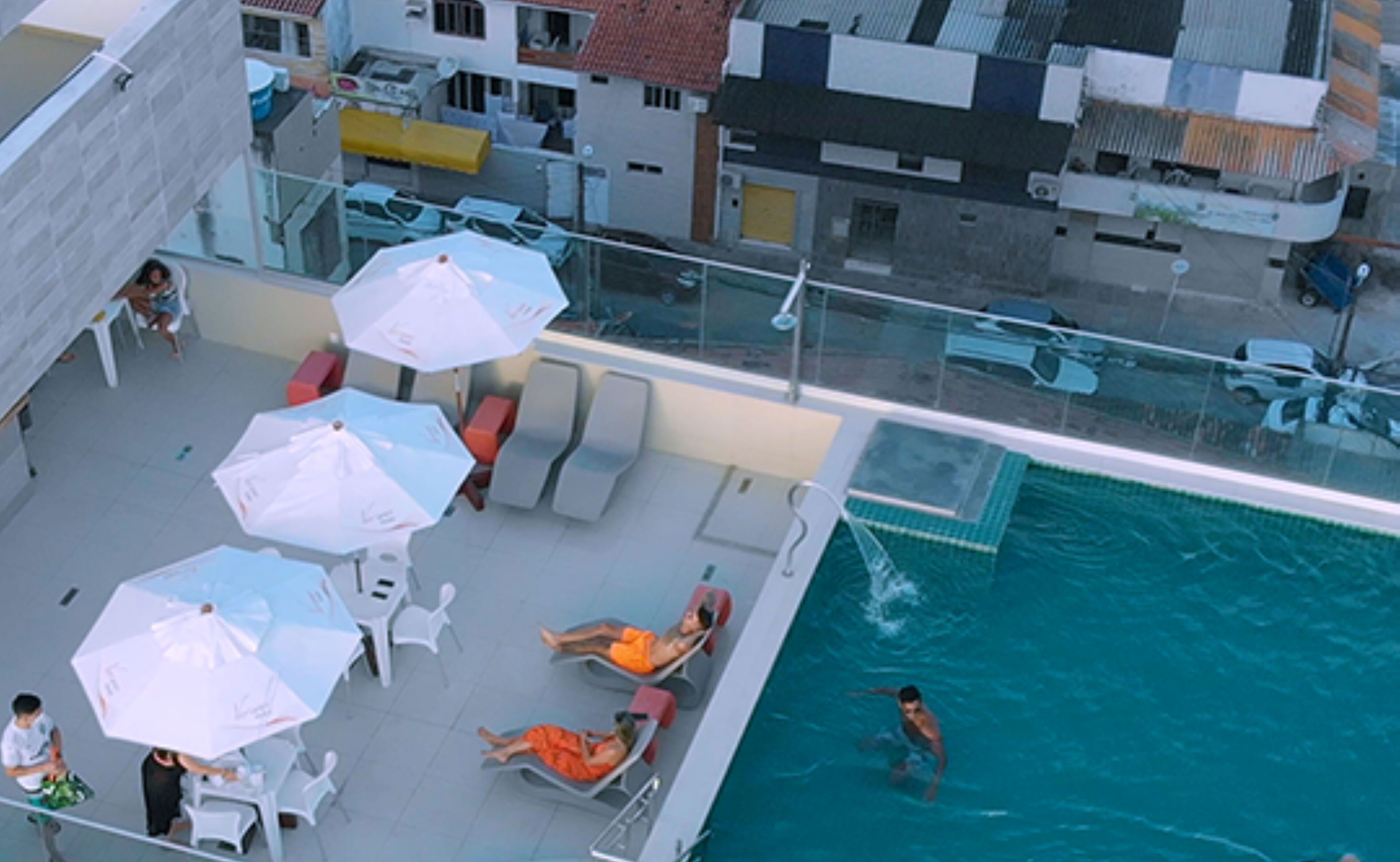 An outdoor swimming pool with lounge chairs and umbrellas.