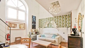 Ein Wohnzimmer mit einem weißen Sofa, einem Couchtisch und einer Chandelier.