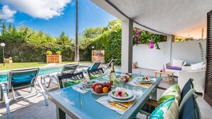 An outdoor dining area with a pool, chairs, and a table set for a meal. - House with pool garden Casa Pequeña in Mallorca (Crestatx)