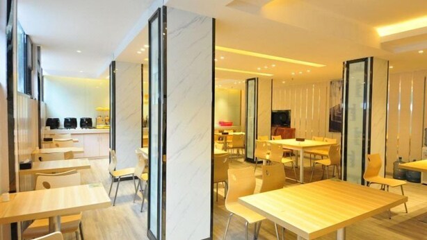 A modern dining area with marble partitions, wooden tables, and chairs. - City Comfort Inn (Guangzhou Taihe Plaza) (Guangzhou)