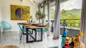 Ein Balkon mit Esstisch, Stühlen und einer Tablett mit Spirituosen.