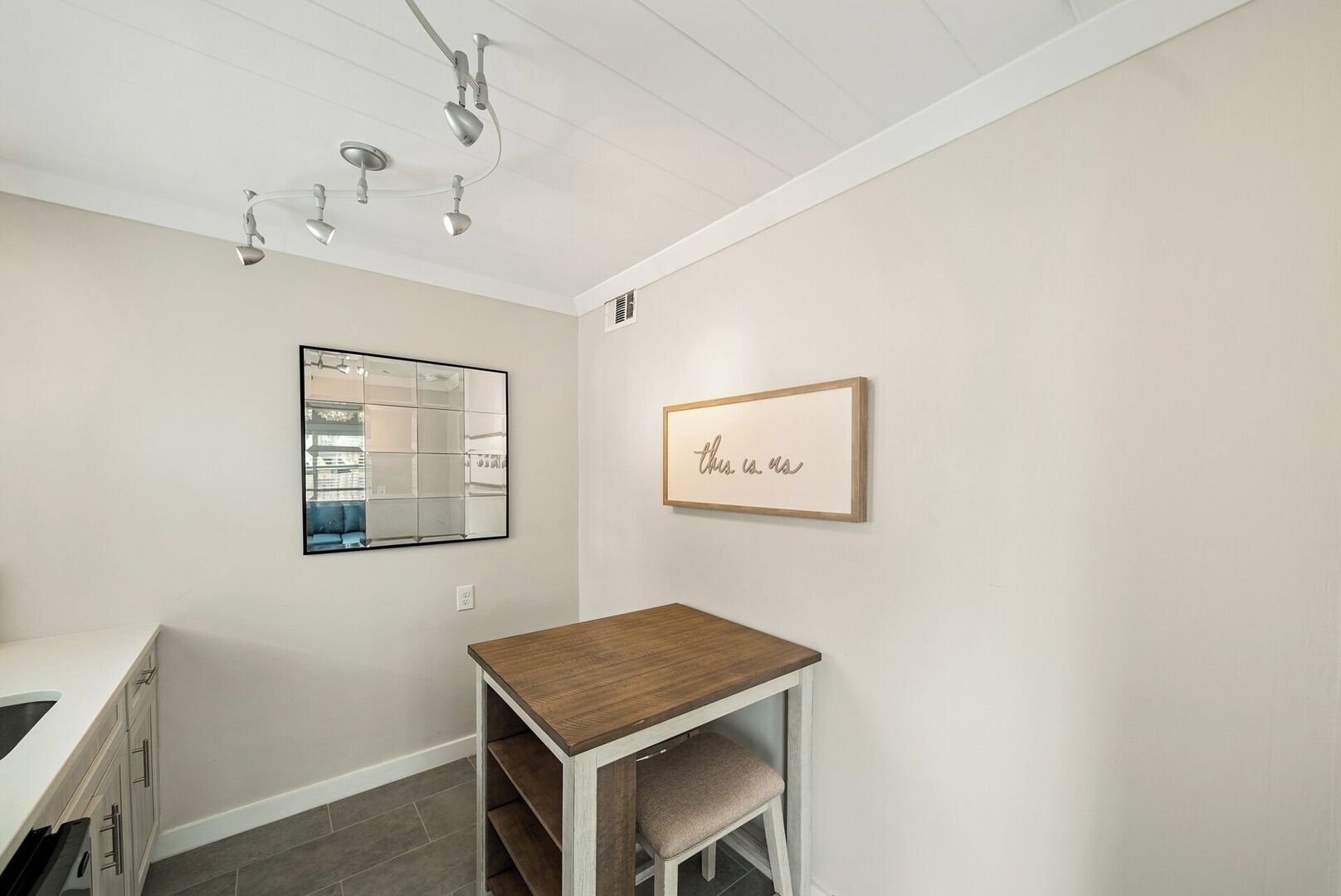 A modern kitchen with white cabinets, a wooden countertop, and a built-in oven.
