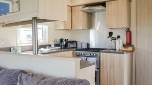 Cocina compacta con estufa, tostadora y cafetera.