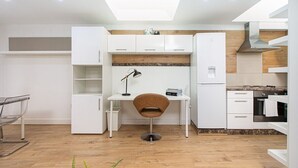 A compact kitchen with white cabinetry, a central island, and a skylight.