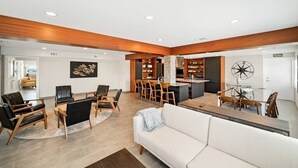 A modern hotel lobby with a central dining area, a reception desk, and a seating area with sofas and chairs. - Compass 2BR Suite - Gourmet Kitchen - Water view (Cocoa Beach)
