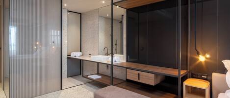 A modern bathroom with a large mirror, a wooden vanity, and a bench.