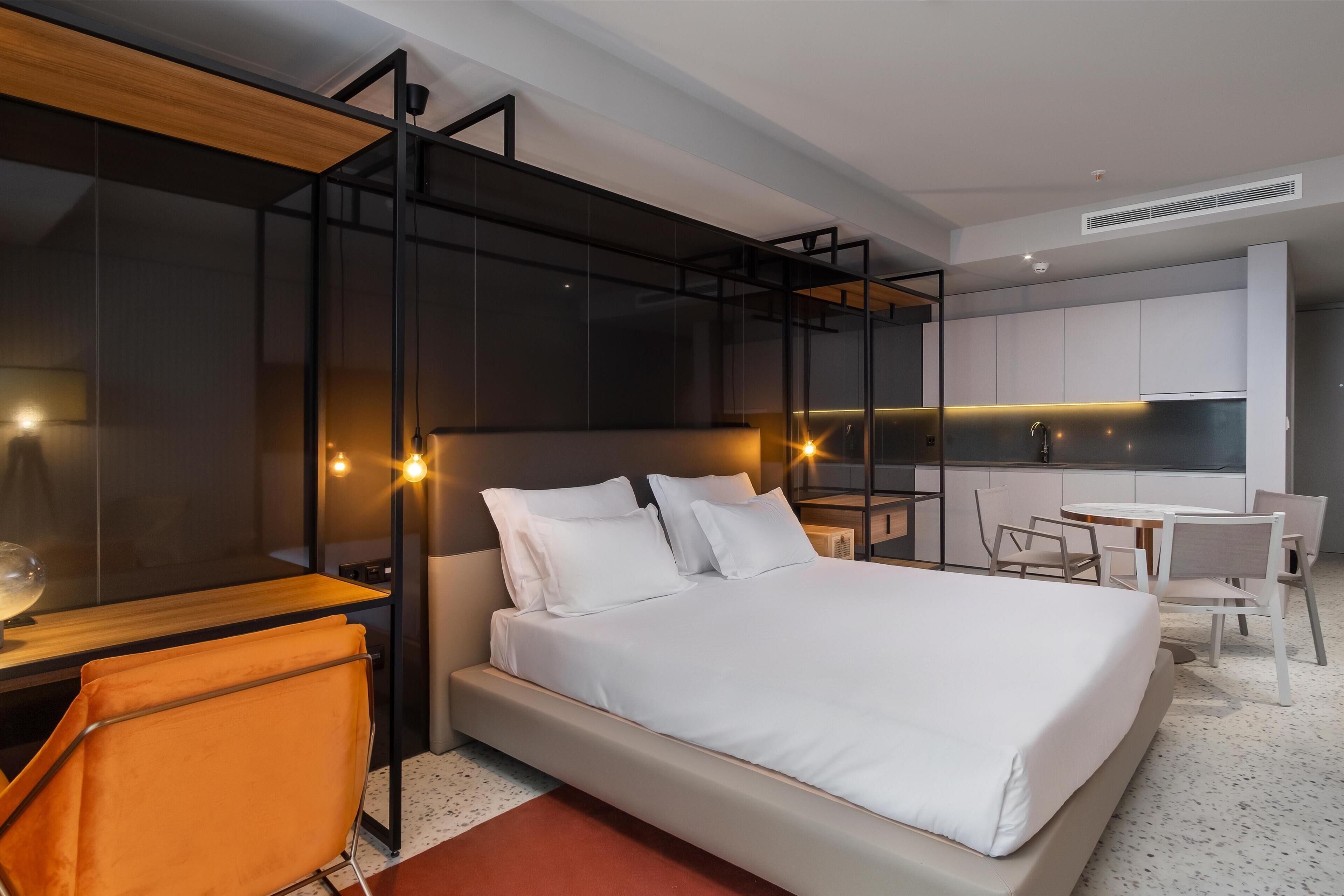 Ett modernt hotellrum med en stor säng, ett skrivbord och en matplats.