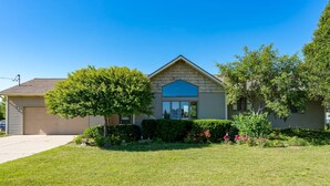 A single-story house with a gabled roof, a front porch, and a well-maintained lawn. - Downstairs Half of Home 3 bedrooms 1.5 bath 6 beds (Hudsonville)
