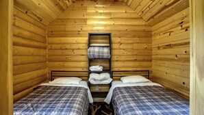 A cabin with two beds, a shelf with folded clothes, and a ceiling fan. - Turtle Cabin Near Mississippi River (Buffalo City)