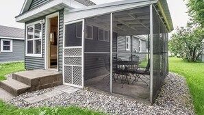A house with a covered patio area featuring a table and chairs. - Turtle Cabin Near Mississippi River (Buffalo City)