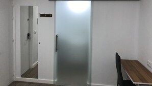 Una habitación con puerta corredera, una mesa de madera y una silla.