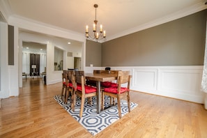 A dining area with a wooden table and chairs, a patterned rug, and a chandelier. - Spacious Luxury Home in the Heart of it ALL: 5 Bedroom, 5.5 bathrooms (Arlington)