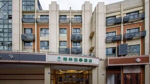 A hotel entrance with a modern facade, multiple balconies, and a clear entrance. - Greentree Inn Suzhou Kunshan Huaqiao Metro Station Express Hotel (Suzhou)