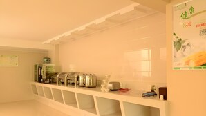 A clean, modern kitchen with stainless steel appliances, a white countertop, and a wall-mounted menu board. - Greentree Inn Suzhou Kunshan Huaqiao Metro Station Express Hotel (Suzhou)