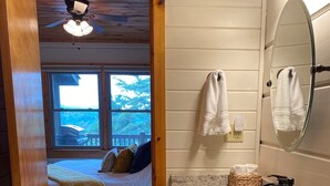 A bedroom with a bed, a wooden ceiling fan, and a window with a view of the outdoors. - The Hygge at Blue Ridge - Beautiful Mtn view, 3 Fire types, Hot Tub (Blue Ridge)