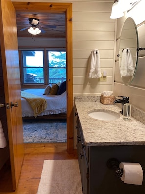 A bedroom with a bed, a wooden ceiling fan, and a window with a view of the outdoors. - The Hygge at Blue Ridge - Beautiful Mtn view, 3 Fire types, Hot Tub (Blue Ridge)
