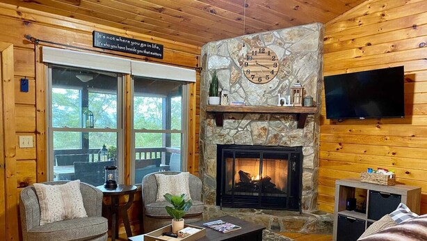 A cozy cabin interior with a stone fireplace, wooden walls, and a comfortable seating area. - The Hygge at Blue Ridge - Beautiful Mtn view, 3 Fire types, Hot Tub (Blue Ridge)