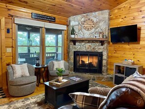 A cozy cabin interior with a stone fireplace, wooden walls, and a comfortable seating area. - The Hygge at Blue Ridge - Beautiful Mtn view, 3 Fire types, Hot Tub (Blue Ridge)