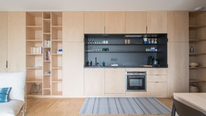 Una cocina moderna con armarios de madera, horno integrado y encimera negra.