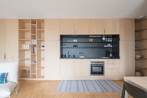 Cozy living space with a kitchenette, featuring an oven and seating area.
