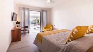 A hotel room with a bed, a desk, a chair, a television, and a view of the outdoors.