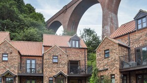 Una hilera de casas de ladrillo con un puente grande al fondo.