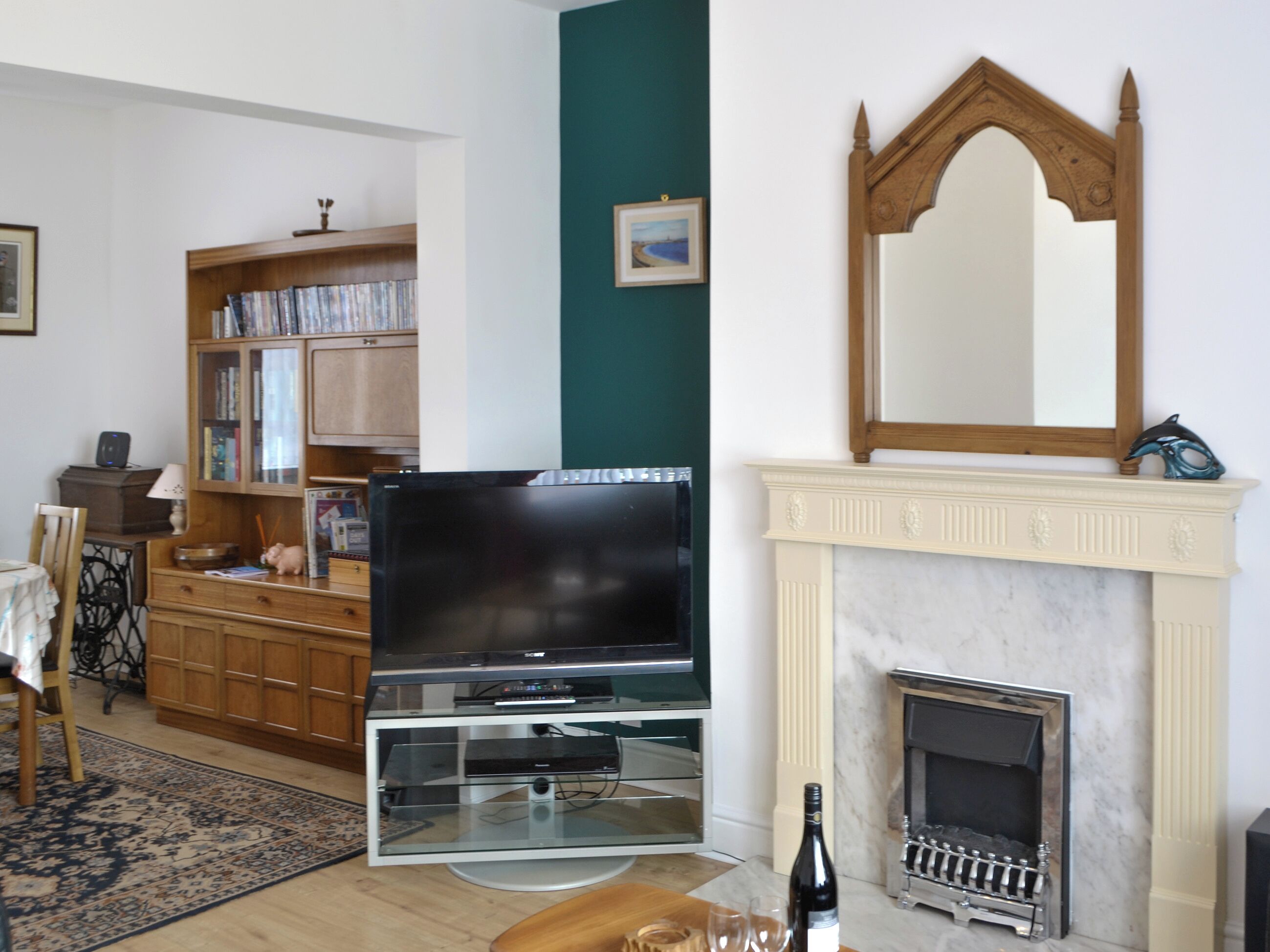 Una sala de estar con televisión, chimenea y estanterías.