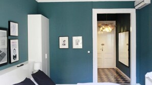 A bedroom with a bed, a wardrobe, and a hallway leading to a bathroom. - Bed and Break Barcelona (Barcelona)