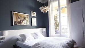 A bedroom with a bed, a window with curtains, and wall-mounted artwork. - Bed and Break Barcelona (Barcelona)