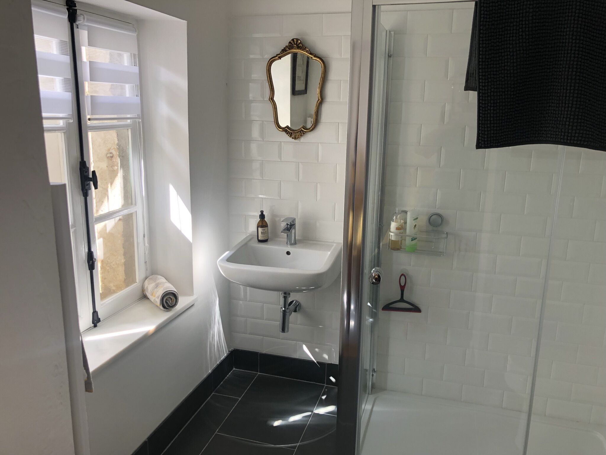 Ein Badezimmer mit Waschbecken, Spiegel, Toilette und Dusche.