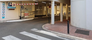 A parking entrance with a barrier gate, a sign for 'Suquet Forville', and a no parking sign.