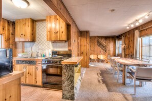Enjoy cooking in this well-equipped kitchen with a central island, stove, sink, refrigerator, and microwave.