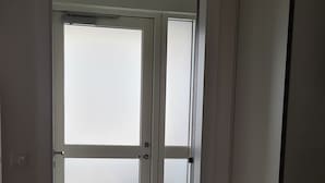 Eine moderne Küche mit weißen Schränken, einem eingebauten Backofen und einer Milchglasschiebetür.
