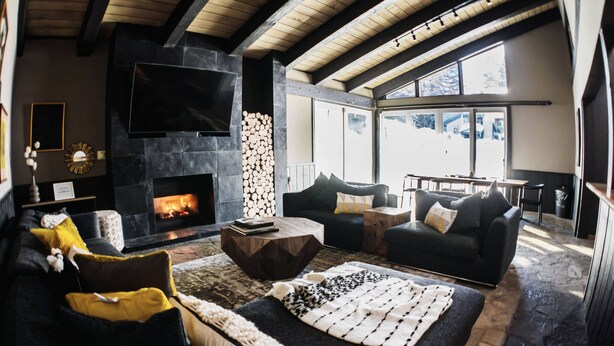 A cozy living room with a fireplace, comfortable seating, and a large TV. - Chamonix - Year-round Fun w/ Shared Pool! (Mammoth Lakes)