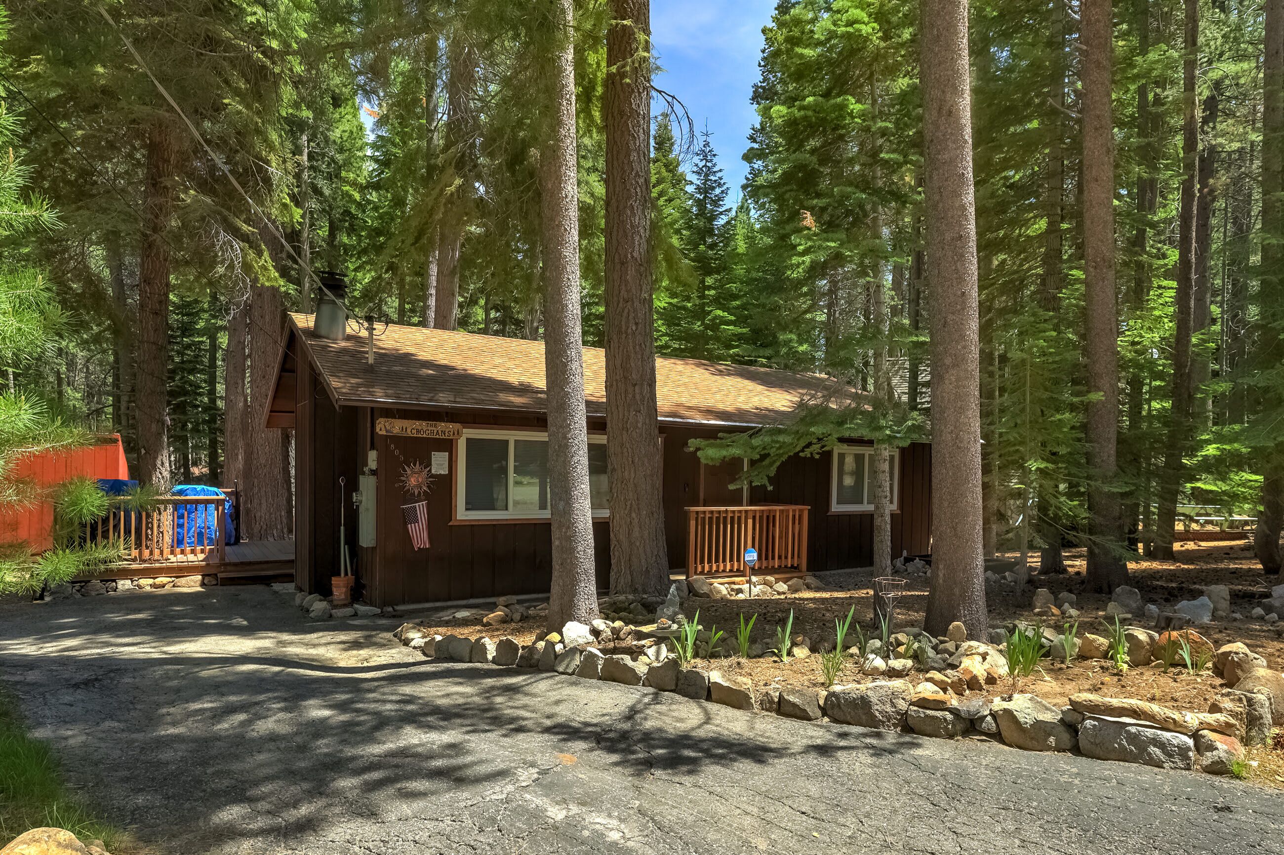 A cabin with a wooden exterior, a porch, and a small deck.