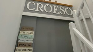 A staircase with a sign reading "CROESO" and a list of cottage rules including staying up late, sleeping in, and making memories. - 2 bedroom accommodation in Criccieth (Criccieth)