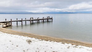 A wooden pier extending into calm waters with a snowy beach in the foreground. - Waters Edge Escape Patio w/ Bbq, Near Beach (Tahoma)