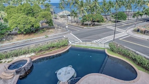 A swimming pool with a hot tub, surrounded by palm trees and a view of the ocean. - The Beach Villas w/ Pool Hot Tub & A/c! (Kailua-Kona)