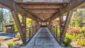 A wooden covered walkway with a sign reading "Lodge" leading to a building.