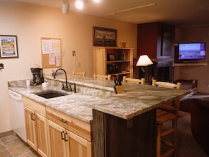 Kitchen area with a sink, coffee maker, and dining space with a table and chairs.